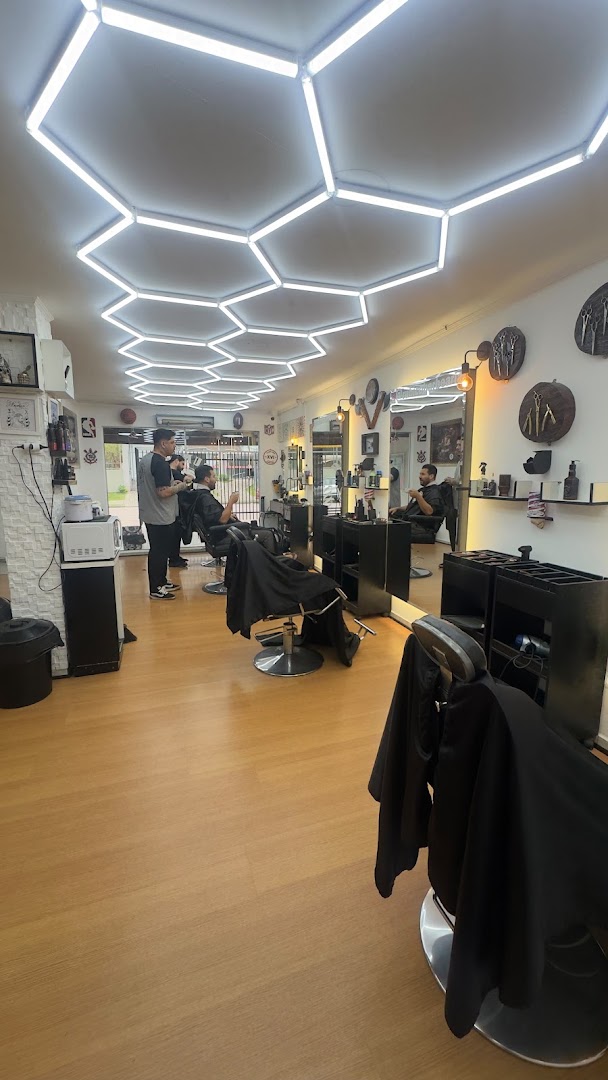 Barbeiro atendendo um cliente dentro da Rubico Barber Shop, no Boqueirão